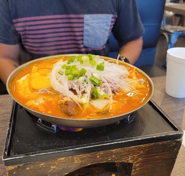 a bowl of ramen on top of heater on a table